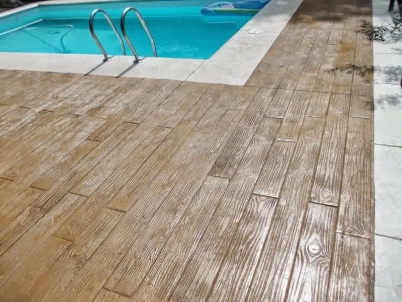 Borde de piscina en hormigón impreso con acabado madera en tono claro